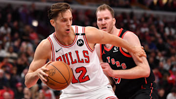 Feb 28, 2025; Chicago, Illinois, USA; Chicago Bulls center Zach Collins (12) controls the ball against the Toronto Raptors center Jakob Poeltl (19) during the second half at the United Center. Mandatory Credit: Patrick Gorski-Imagn Images