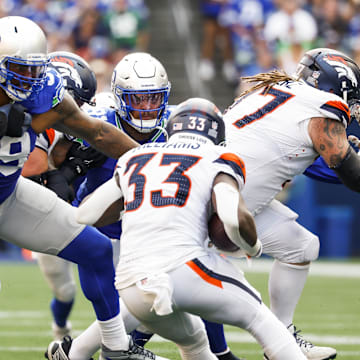 Sep 8, 2024; Seattle, Washington, USA; Seattle Seahawks defensive end Leonard Williams (99) and Seattle Seahawks defensive tackle Byron Murphy II (91) tackle Denver Broncos running back Javonte Williams (33) for a loss during the fourth quarter at Lumen Field. Mandatory Credit: Joe Nicholson-Imagn Images