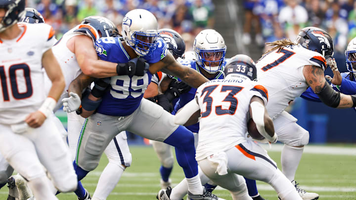 Sep 8, 2024; Seattle, Washington, USA; Seattle Seahawks defensive end Leonard Williams (99) and Seattle Seahawks defensive tackle Byron Murphy II (91) tackle Denver Broncos running back Javonte Williams (33) for a loss during the fourth quarter at Lumen Field. Mandatory Credit: Joe Nicholson-Imagn Images