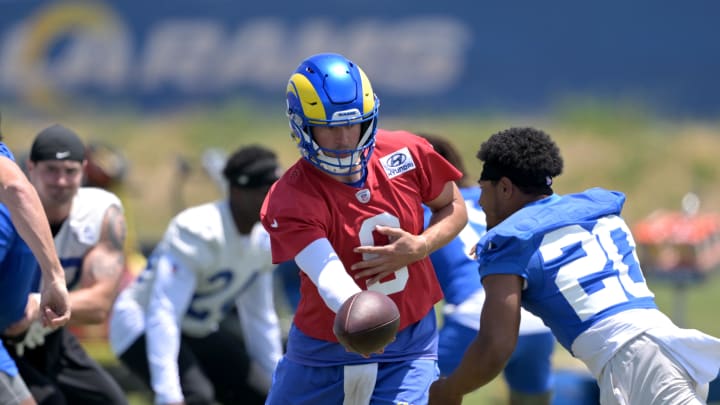 May 28, 2024; Thousand Oaks, CA, USA;  Los Angeles Rams quarterback Matthew Stafford (9) hands off to Rams running back Ronnie Rivers (20) during OTAs at California Lutheran University. Mandatory Credit: Jayne Kamin-Oncea-USA TODAY Sports