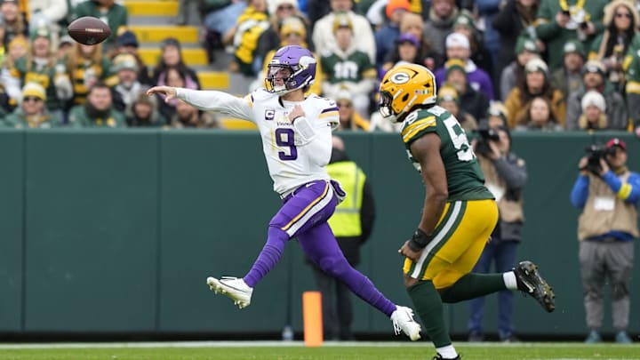 Nov 23, 2025; Green Bay, Wisconsin, USA; Minnesota Vikings quarterback J.J. McCarthy (9) throws downfield as Green Bay Packers defensive end Kingsley Enagbare (55) defends during the first half at Lambeau Field. Mandatory Credit: Jeff Hanisch-Imagn Images