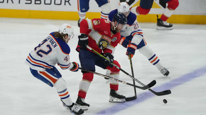Jun 12, 2025; Sunrise, Florida, USA; Florida Panthers forward Sam Bennett (9) controls the puck against Edmonton Oilers right wing Kasperi Kapanen (42) and center Leon Draisaitl (29) during the first period in game four of the 2025 Stanley Cup Final at Amerant Bank Arena. Mandatory Credit: Jim Rassol-Imagn Images