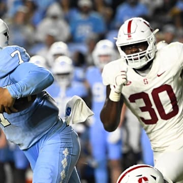 Nov 8, 2025; Chapel Hill, North Carolina, USA; North Carolina Tar Heels quarterback Gio Lopez (7) breaks a tackle as Stanford Cardinal linebacker Matt Rose (35) defends in the third quarter at Kenan Stadium. Mandatory Credit: Bob Donnan-Imagn Images