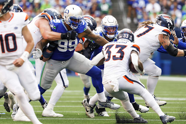 Seattle Seahawks defensive end Leonard Williams (99) and defensive tackle Byron Murphy II tackle Javonte Williams.