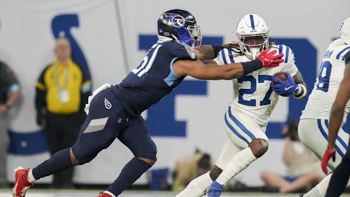 Dec 22, 2024; Indianapolis, Indiana, USA; Tennessee Titans linebacker Cedric Gray (51) reaches for Indianapolis Colts running back Trey Sermon (27) during a game against the Tennessee Titans at Lucas Oil Stadium. Mandatory Credit: Christine Tannous/USA Today Network via Imagn Images 