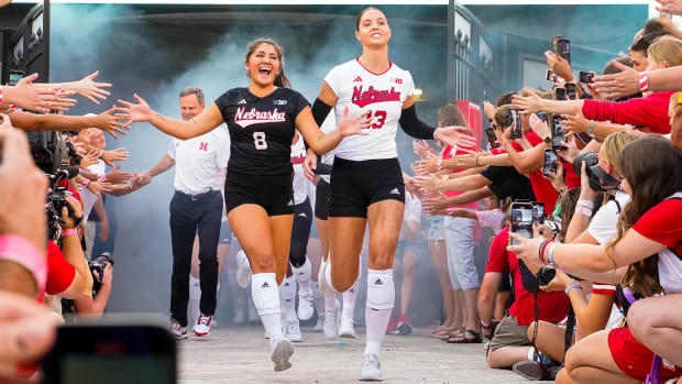 Nebraska Cornhuskers outside hitter Merritt Beason (13) and libero Lexi Rodriguez (8) run out of the tunnel before the match