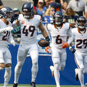 Sep 8, 2024; Seattle, Washington, USA; Denver Broncos linebacker Alex Singleton (49) celebrates with cornerback Riley Moss (21), safety P.J. Locke (6) and cornerback Ja'Quan McMillian (29) after intercepting a pass against the Seattle Seahawks during the first quarter at Lumen Field. 