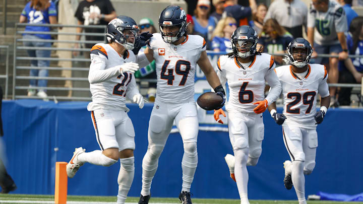 Sep 8, 2024; Seattle, Washington, USA; Denver Broncos linebacker Alex Singleton (49) celebrates with cornerback Riley Moss (21), safety P.J. Locke (6) and cornerback Ja'Quan McMillian (29) after intercepting a pass against the Seattle Seahawks during the first quarter at Lumen Field. 