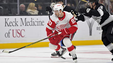 Nov 16, 2024; Los Angeles, California, USA; Detroit Red Wings right wing Alex DeBrincat (93) keeps the puck from Los Angeles Kings center Phillip Danault (24) and left wing Kevin Fiala (22) in the first period at Crypto.com Arena. Mandatory Credit: Jayne Kamin-Oncea-Imagn Images