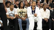 Apr 13, 2025; San Antonio, Texas, USA; San Antonio Spurs (from left to right) forward Keldon Johnson (0), guard Devin Vassell (24), center Victor Wembanyama (1) and guard De'Aron Fox (4) watch the first half of a game against the Toronto Raptors at Frost Bank Center. Mandatory Credit: Scott Wachter-Imagn Images