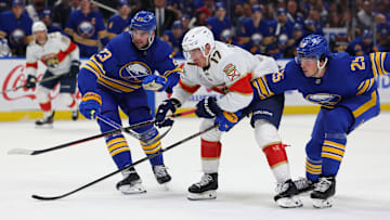 Oct 12, 2024; Buffalo, New York, USA;  Buffalo Sabres defenseman Mattias Samuelsson (23), Florida Panthers center Evan Rodrigues (17) and Buffalo Sabres defenseman Owen Power (25) race to a loose puck during the third period at KeyBank Center. Mandatory Credit: Timothy T. Ludwig-Imagn Images