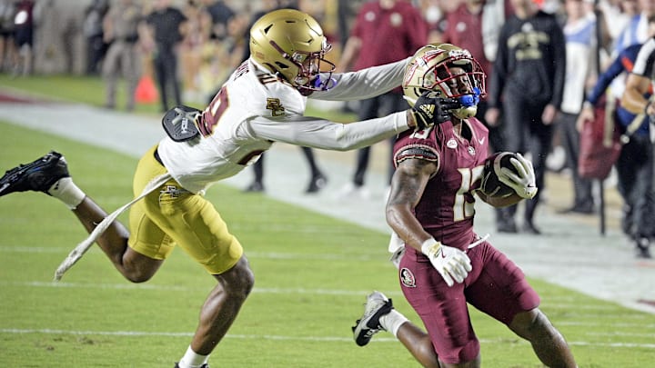Sep 2, 2024; Tallahassee, Florida, USA; Florida State Seminoles running back Jaylin Lucas (13) is tackled by Boston College Eagles defensive back Carter Davis (28) during the first half at Doak S. Campbell Stadium. Mandatory Credit: Melina Myers-Imagn Images