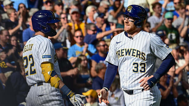 Milwaukee Brewers catcher Danny Jansen is greeted by designated hitter Christian Yelich.
