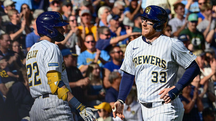 Milwaukee Brewers catcher Danny Jansen is greeted by designated hitter Christian Yelich.