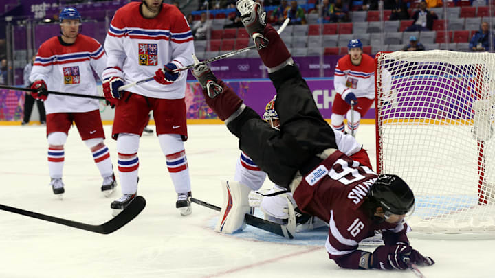 Feb 14, 2014; Sochi, RUSSIA; Latvia forward Kaspars Daugavins (16) trips over the back of Czech Republic goalie Ondrej Pavelec (rear) in a men's preliminary round ice hockey game during the Sochi 2014 Olympic Winter Games at Bolshoy Ice Dome. Mandatory Credit: Winslow Townson-Imagn Images