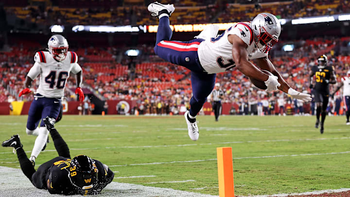 Aug 25, 2024; Landover, Maryland, USA; New England Patriots running back Kevin Harris (36) dives for a touchdown against Washington Commanders safety Jeremy Reaves (39) during the first quarter during a preseason game at Commanders Field. Mandatory Credit: Peter Casey-USA TODAY Sports