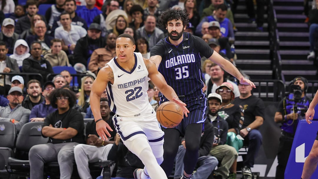 Feb 21, 2025; Orlando, Florida, USA; Memphis Grizzlies guard Desmond Bane (22) moves the ball in front of Orlando Magic center Goga Bitadze (35) during the second quarter at Kia Center. Mandatory Credit: Mike Watters-Imagn Images