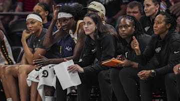 Indiana Fever guard Caitlin Clark follows the action from the bench against the Atlanta Dream.