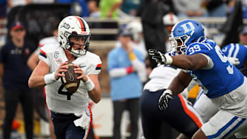 Nov 15, 2025; Durham, North Carolina, USA;  Virginia Cavaliers quarter back Chandler Morris (4) looks for an opening against Duke Blue Devils defensive tackle Aaron Hall (99) during the first quarter at Wallace Wade Stadium. Mandatory Credit: Zachary Taft-Imagn Images