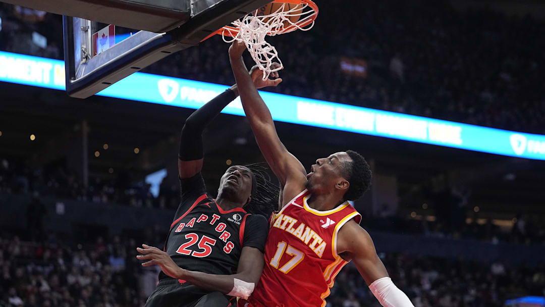 Toronto Raptors forward Chris Boucher (25) goes up to make a basket against Atlanta Hawks forward Onyeka Okongwu (17) during the second half at Scotiabank Arena. Mandatory Credit: John E. Sokolowski-Imagn Images