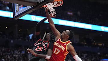 Toronto Raptors forward Chris Boucher (25) goes up to make a basket against Atlanta Hawks forward Onyeka Okongwu (17) during the second half at Scotiabank Arena. Mandatory Credit: John E. Sokolowski-Imagn Images
