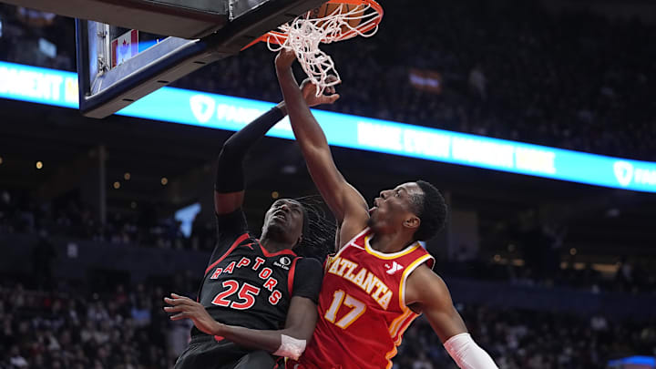 Toronto Raptors forward Chris Boucher (25) goes up to make a basket against Atlanta Hawks forward Onyeka Okongwu (17) during the second half at Scotiabank Arena. Mandatory Credit: John E. Sokolowski-Imagn Images