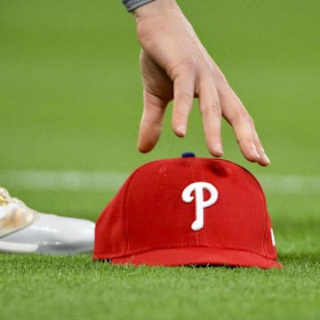 Apr 11, 2025; St. Louis, Missouri, USA;  Philadelphia Phillies third baseman Alec Bohm (28) picks up his hat after chasing down a fly ball against the St. Louis Cardinals during the third inning at Busch Stadium. 
