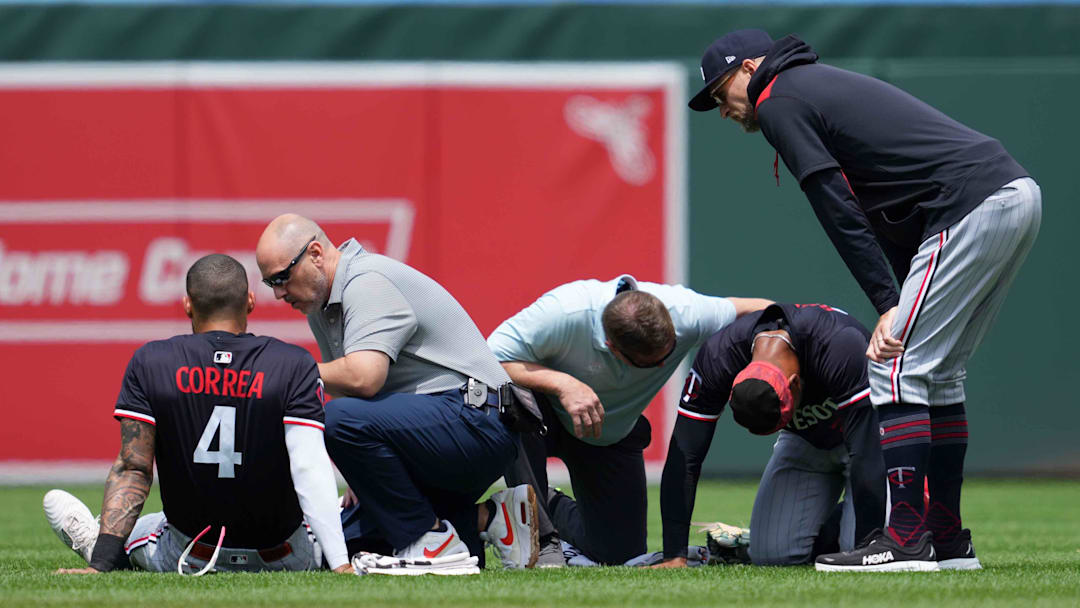 May 15, 2025; Baltimore, Maryland, USA; Minnesota Twins outfielder Byron Buxton (25) and shortstop Carlos Correa (4) remain on the ground following a collision while chasing the ball during the third inning against the Baltimore Orioles at Oriole Park at Camden Yards. Mandatory Credit: Mitch Stringer-Imagn Images