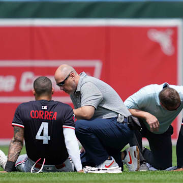 Minnesota Twins outfielder Byron Buxton and shortstop Carlos Correa remain on the ground following a collision while chasing the ball against the Baltimore Orioles.