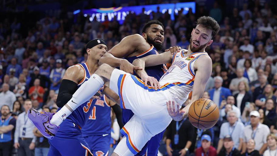 New York Knicks center Karl-Anthony Towns and Oklahoma City Thunder center Chet Holmgren fight for a loose ball.