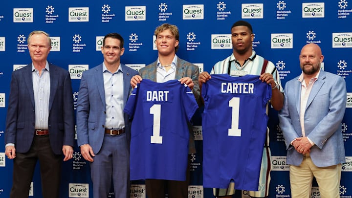 Apr 25, 2025; East Rutherford, NJ, US; New York Giants president John Mara (far left), general manager Joe Schoen (left), Jaxson Dart, Abdul Carter, and head coach Brian Daboll (right) pose for photos prior to the start of the press conference to introduce the Giants first round draft picks. Apr 25, 2025; East Rutherford, NJ, US; New York Giants president John Mara (far left), general manager Joe Schoen (left), Jaxson Dart, Abdul Carter, and head coach Brian Daboll (right) pose for photos prior to the start of the press conference to introduce the Giants first round draft picks.