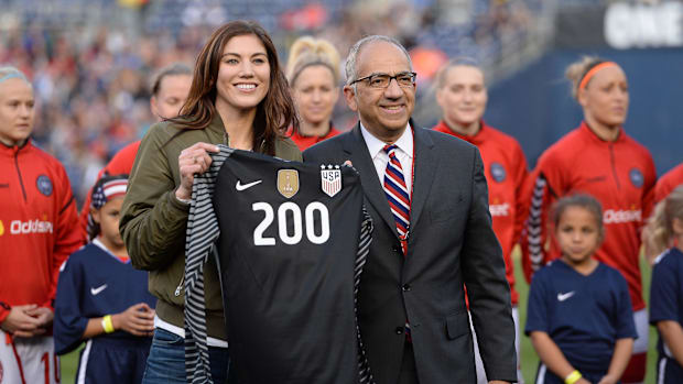 United States soccer vice president Carlos Cordeiro presents former player Hope Solo a commemorative jersey