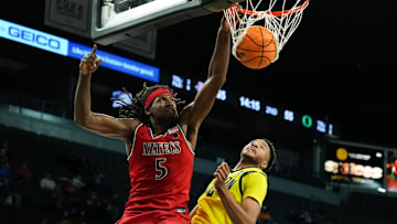 Nov 25, 2025; Las Vegas, Nevada, USA; San Diego State Aztecs forward Pharaoh Compton (5) dunks against Oregon Ducks forward Kwame Evans Jr. (10).