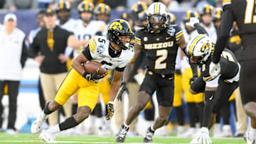 Dec 30, 2024; Nashville, TN, USA;  Iowa Hawkeyes wide receiver Jacob Gill (5) runs through the tackle of Missouri Tigers cornerback Toriano Pride Jr. (2) during the second half at Nissan Stadium. Mandatory Credit: Steve Roberts-Imagn Images