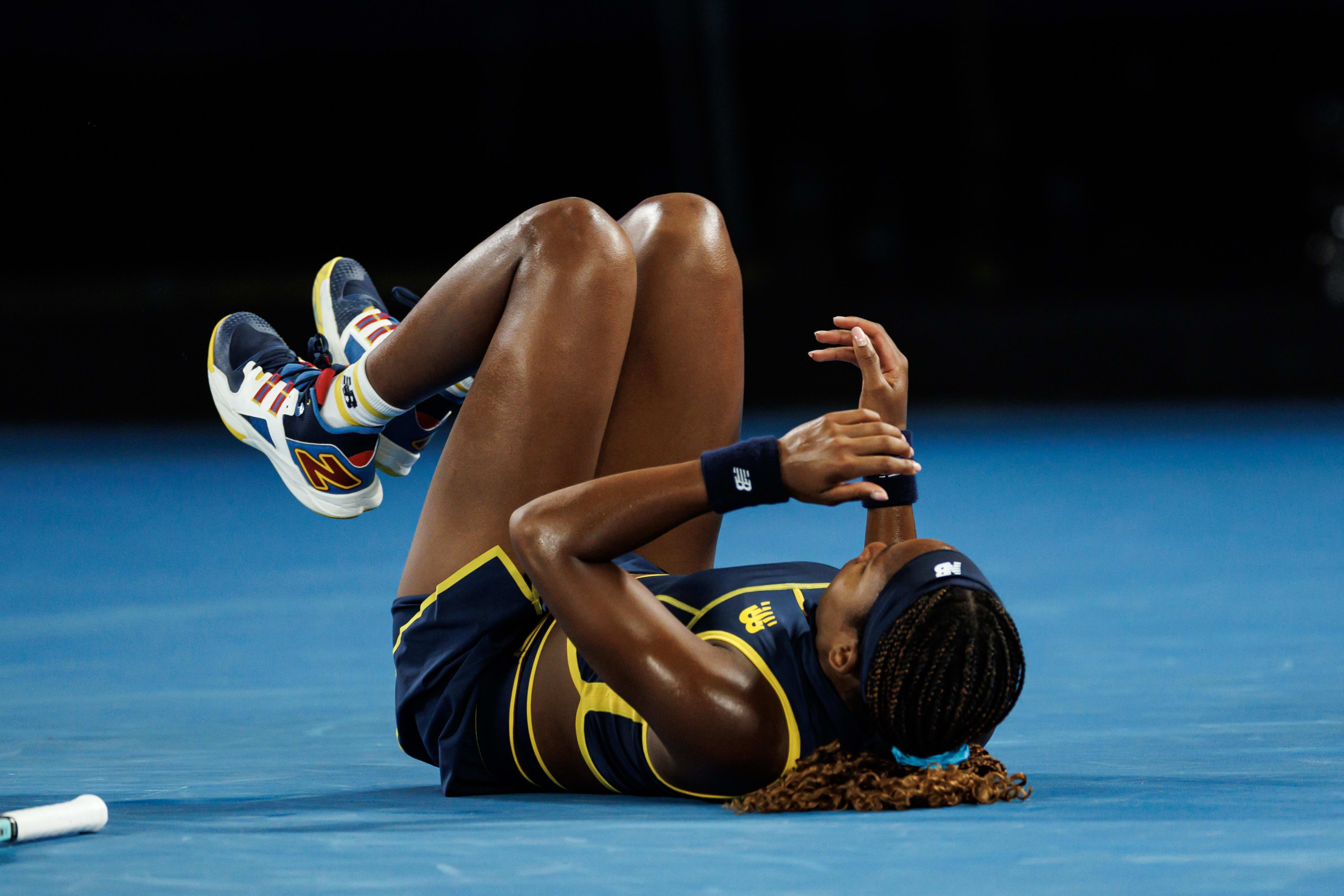 Coco Gauff falls to the court during a tennis match.