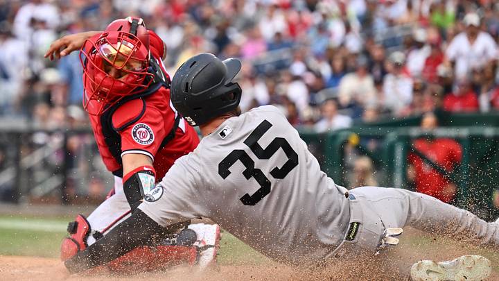 Jul 12, 2026; Washington, District of Columbia, USA;  New York Yankees outfielder Cody Bellinger (35) slides home to score a run just out of the reach of Washington Nationals catcher Keibert Ruiz (20) in the ninth inning at Nationals Park. Mandatory Credit: Jamie Sabau-Imagn Images