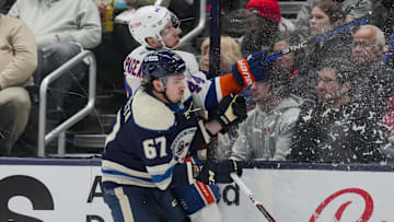 Apr 4, 2024; Columbus, Ohio, USA;  Columbus Blue Jackets left wing James Malatesta (67) checks New York Islanders center Jean-Gabriel Pageau (44) into the boards in the second period at Nationwide Arena. Mandatory Credit: Aaron Doster-Imagn Images
