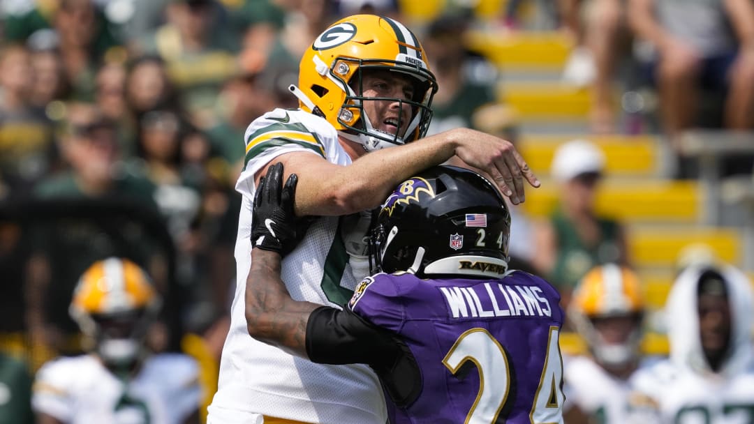 Aug 24, 2024; Green Bay, Wisconsin, USA;  Green Bay Packers quarterback Sean Clifford (6) is hit by Baltimore Ravens cornerback Damarion Williams (24) after throwing a pass during the first quarter at Lambeau Field. Mandatory Credit: Jeff Hanisch-USA TODAY Sports