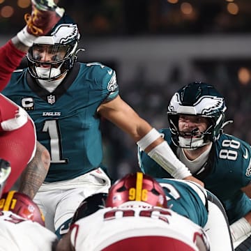 Jan 26, 2025; Philadelphia, PA, USA; Philadelphia Eagles quarterback Jalen Hurts (1) reacts as Washington Commanders linebacker Frankie Luvu (4) leaps over linemen before a snap during the second half in the NFC Championship game at Lincoln Financial Field. Mandatory Credit: Bill Streicher-Imagn Images