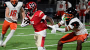 Cardinal Mooney ball carrier Marcus Galloway (#4) is stopped when Cocoa High defensive back CJ Hester (#1) grabs his jersey. Cocoa High School defeated Cardinal Mooney Catholic High School 31-21 to win the Class 2A semi-final game Friday night in Sarasota.