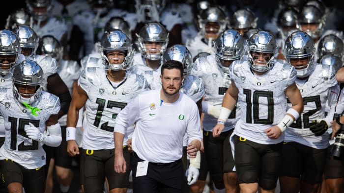 Nov 18, 2023; Tempe, Arizona, USA; Oregon Ducks head coach Dan Lanning (center) leads quarterback Bo