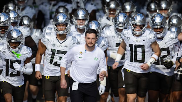 Oregon Ducks head coach Dan Lanning (center) leads quarterback Bo Nix (10) and Ty Thompson (13) onto the field for the game a