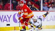 Nov 27, 2023; Calgary, Alberta, CAN; Calgary Flames center Mikael Backlund (11) and Vegas Golden Knights right wing Michael Amadio (22) battle for the puck during the third period at Scotiabank Saddledome. Mandatory Credit: Sergei Belski-Imagn Images