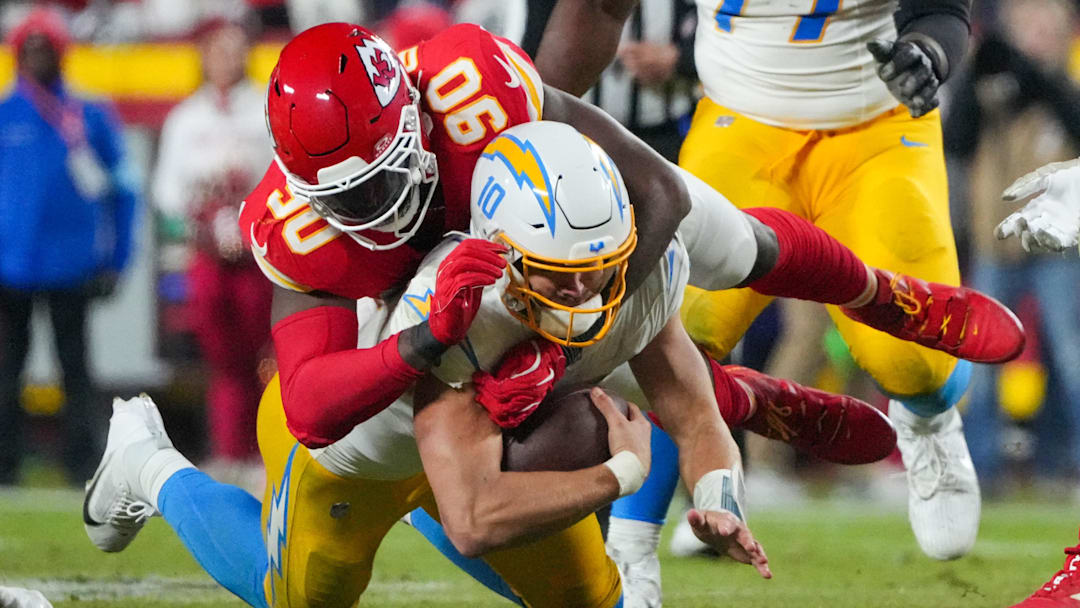 Dec 8, 2024; Kansas City, Missouri, USA; Los Angeles Chargers quarterback Justin Herbert (10) is sacked by Kansas City Chiefs defensive end Charles Omenihu (90) during the second half at GEHA Field at Arrowhead Stadium. Mandatory Credit: Denny Medley-Imagn Images