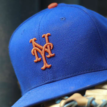 Jul 13, 2022; Atlanta, Georgia, USA; A detailed view of a New York Mets hat and glove in the dugout against the Atlanta Braves in the eighth inning at Truist Park.