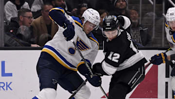 Mar 5, 2025; Los Angeles, California, USA;  St. Louis Blues defenseman Cam Fowler (17) vies for the puck with Los Angeles Kings left wing Trevor Moore (12) during the second period at Crypto.com Arena. Mandatory Credit: Alex Gallardo-Imagn Images
