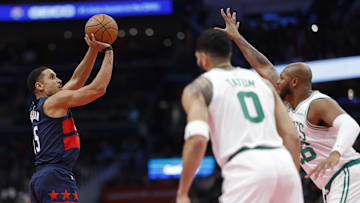Nov 22, 2024; Washington, District of Columbia, USA; Washington Wizards guard Malcolm Brogdon (15) shoots the ball over Boston Celtics forward Xavier Tillman (26) as Boston Celtics forward Jayson Tatum (0) looks on in the second half at Capital One Arena. Mandatory Credit: Geoff Burke-Imagn Images