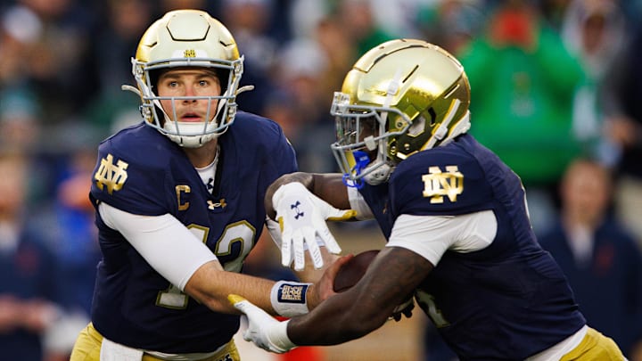 Notre Dame quarterback Riley Leonard (13) hands the ball off to running back Jeremiyah Love (4) during a NCAA college football game against Virginia at Notre Dame Stadium on Saturday, Nov. 16, 2024, in South Bend.