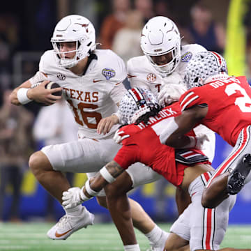 Texas Longhorns quarterback Arch Manning (16) runs against Ohio State Buckeyes cornerback Jordan Hancock (7) and safety Caleb Downs (2) during the second quarter of the College Football Playoff semifinal in the Cotton Bowl at AT&T Stadium. Mandatory Credit: Tim Heitman-Imagn Images