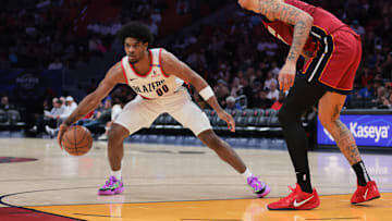 Jan 21, 2025; Miami, Florida, USA; Portland Trail Blazers guard Scoot Henderson (00) dribbles the basketball as Miami Heat center Kel'el Ware (7) defends during the third quarter at Kaseya Center. Mandatory Credit: Sam Navarro-Imagn Images